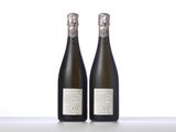 two bottles of champagne sitting on top of a white table