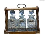 une image représentant une carafe en bois et en verre contenant trois bouteilles