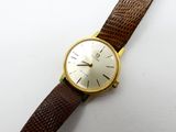 une image d'une montre-bracelet en or avec un bracelet en cuir marron