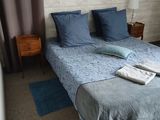 a bed with a blue comforter and two pillows on it