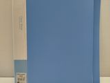 a blue folder sitting on a white table next to a white wall