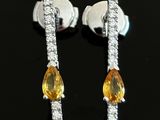 pair of yellow sapphire and diamond earrings on a black surface