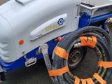 an image of a white and blue trailer with a hose attached to it