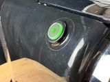 a close up of a toaster with a green button on it