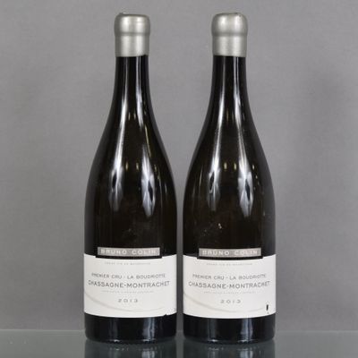 two bottles of wine sitting on top of a table next to each other