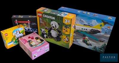 three boxes of legos sitting on a black surface