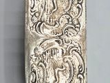 a close up of a silver object on a gray surface
