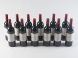 six bottles of red wine lined up in a row on a white surface