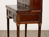 a small desk with a mirror on top of it