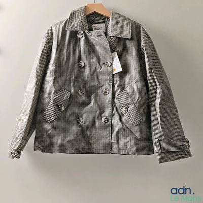 the jacket is hanging on a hanger on the wall