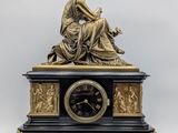 une statue de femme assise au sommet d'une horloge