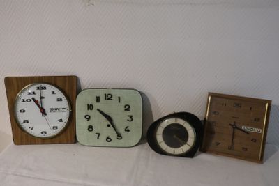 three different clocks sitting on a table next to each other
