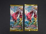 Deux paquets de cartes à collectionner Pokémon sont posés sur une table.