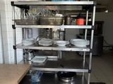 a kitchen with a stove, dish rack, sink and dishwasher in it