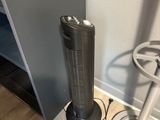 a fan that is sitting on the floor next to a chair