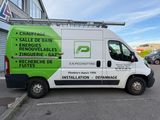 a white van parked in a parking lot with a green and white sign on the side of it