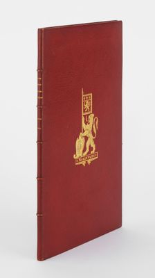 un livre rouge avec un logo doré sur la couverture