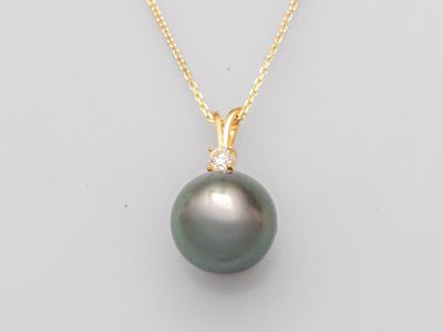 un pendentif composé d'une perle noire et de diamants, monté sur une chaîne en or