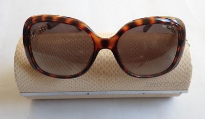 des lunettes de soleil marron posées sur une boîte blanche, sur fond blanc