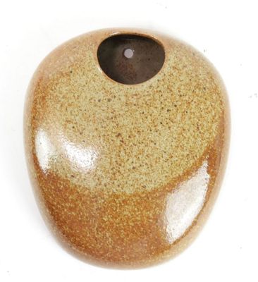 a stone with a hole in it on a white surface