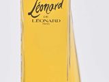 flacon de parfum en verre jaune avec un bouchon transparent, posé sur une surface blanche