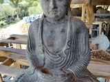 statue représentant une personne assise sur un banc en bois devant un bâtiment
