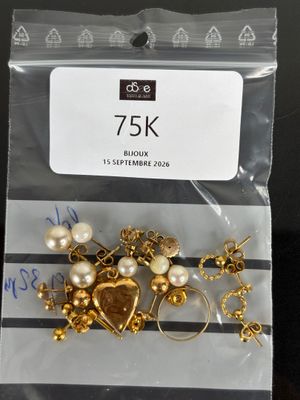 a bag of gold and pearl jewelry on a table