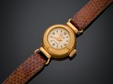 gros plan d'une montre-bracelet avec un bracelet en cuir marron