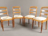 On voit trois chaises en bois avec des assises rembourrées sur un fond gris