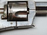 a silver revolver with a black handle on a white surface
