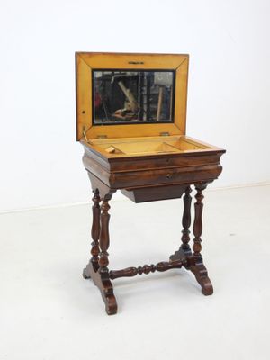 a small wooden table with a mirror on top of it