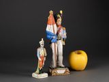 a figurine of a soldier holding a flag next to an apple