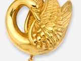 une paire de broches en forme de cygne de couleur dorée sur fond blanc