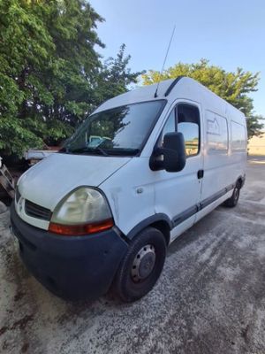 une camionnette blanche garée sur un parking avec des arbres en arrière-plan