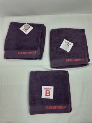 Trois serviettes violettes portant le nom « bensmon » sont posées sur une table