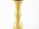 a yellow vase with a flower on a white background
