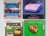 quatre livres posés sur une table blanche, avec un livre sur Porsche par-dessus
