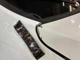 a sticker on the hood of a car that is parked in a showroom