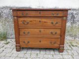 une commode en bois posée sur un sol en briques