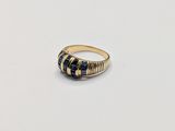 a close up of a gold and blue stone ring on a white surface