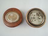 pair of small wooden boxes with decorative designs on them on a white surface