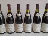 six bottles of wine are lined up in a row on a table