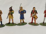 four figurines of men dressed in medieval clothing and weapons