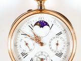 gros plan d'une montre de poche en or sur fond blanc