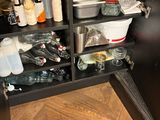 a kitchen cabinet with a lot of dishes and utensils in it
