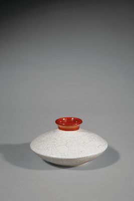 un vase blanc et rouge posé sur une table