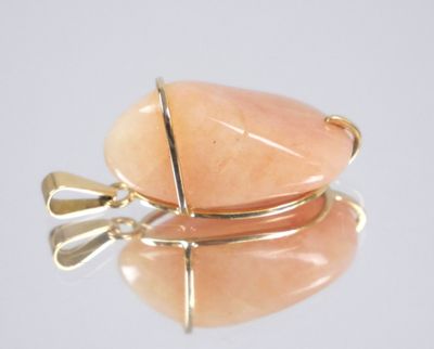 a picture of a pendant with a pink stone on it
