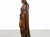 a wooden statue of a man with a cloak on his head