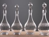 three glass decanters with a bird on top of them on a table