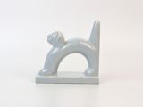 a white cat figurine sitting on top of a white table